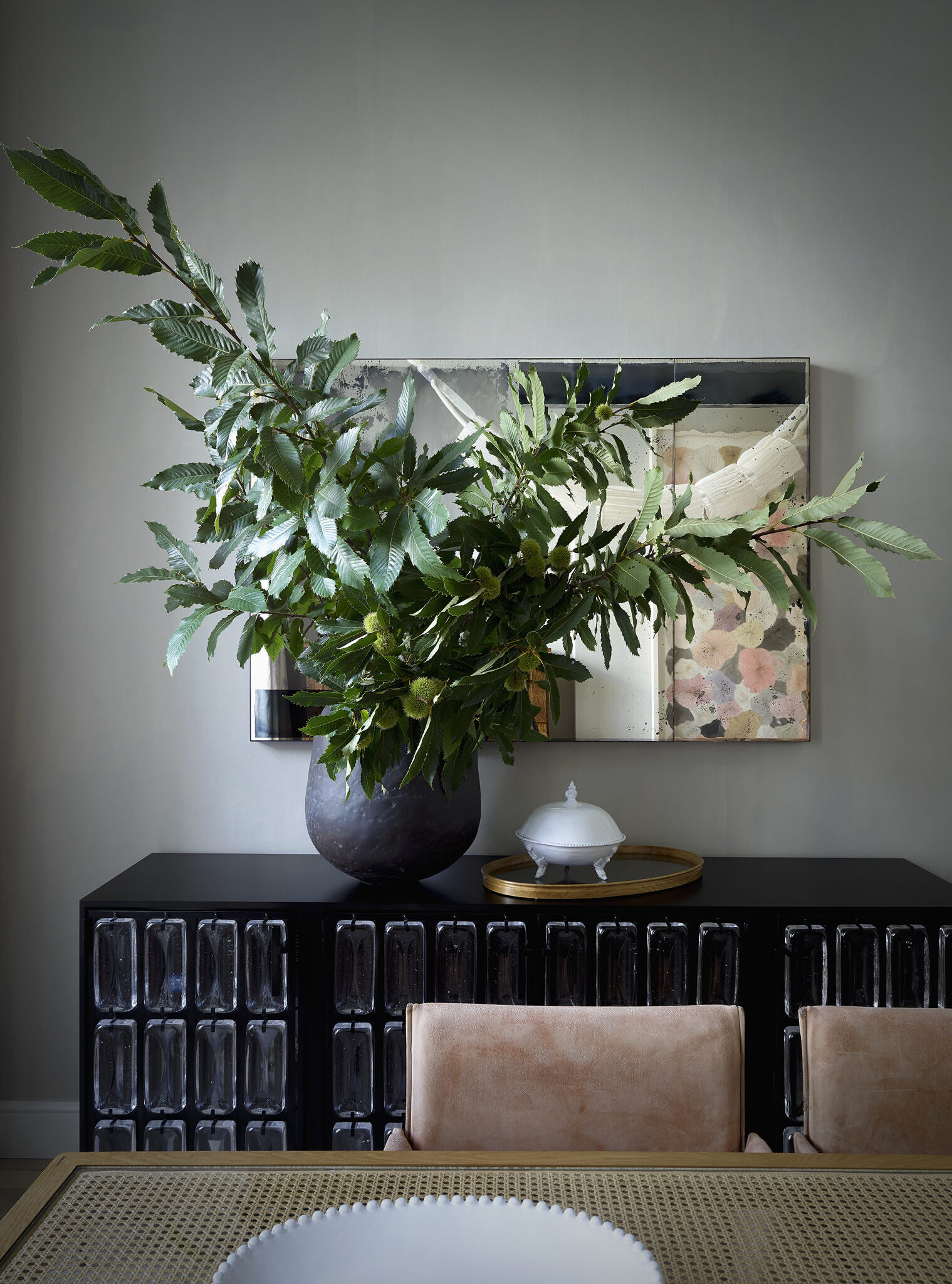 Close up shot of a very large green plant, behind the dining room table.