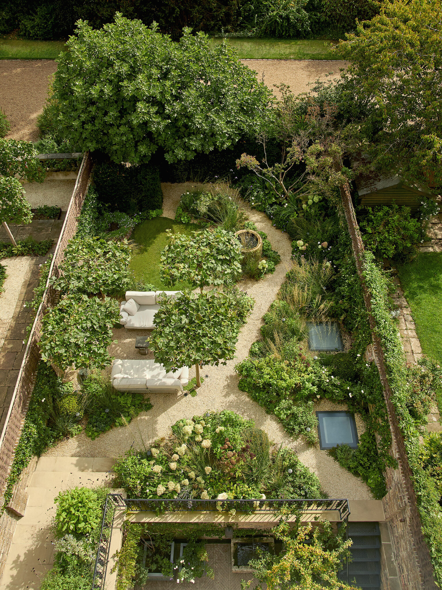 Aerial view image of the outside garden, with pathways throughout and a seating area to the left side.
