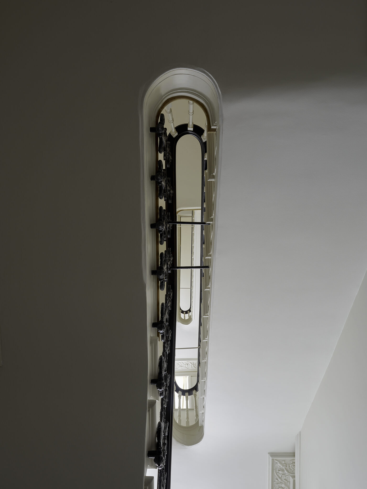 Closeup shot of the multiple floors, as seen through the curved staircase. The image is taken from below.